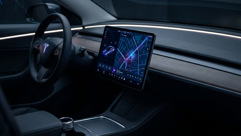 Stor Tesla-touchskjerm som lyser i mørkt interiør, Model Y Juniper
